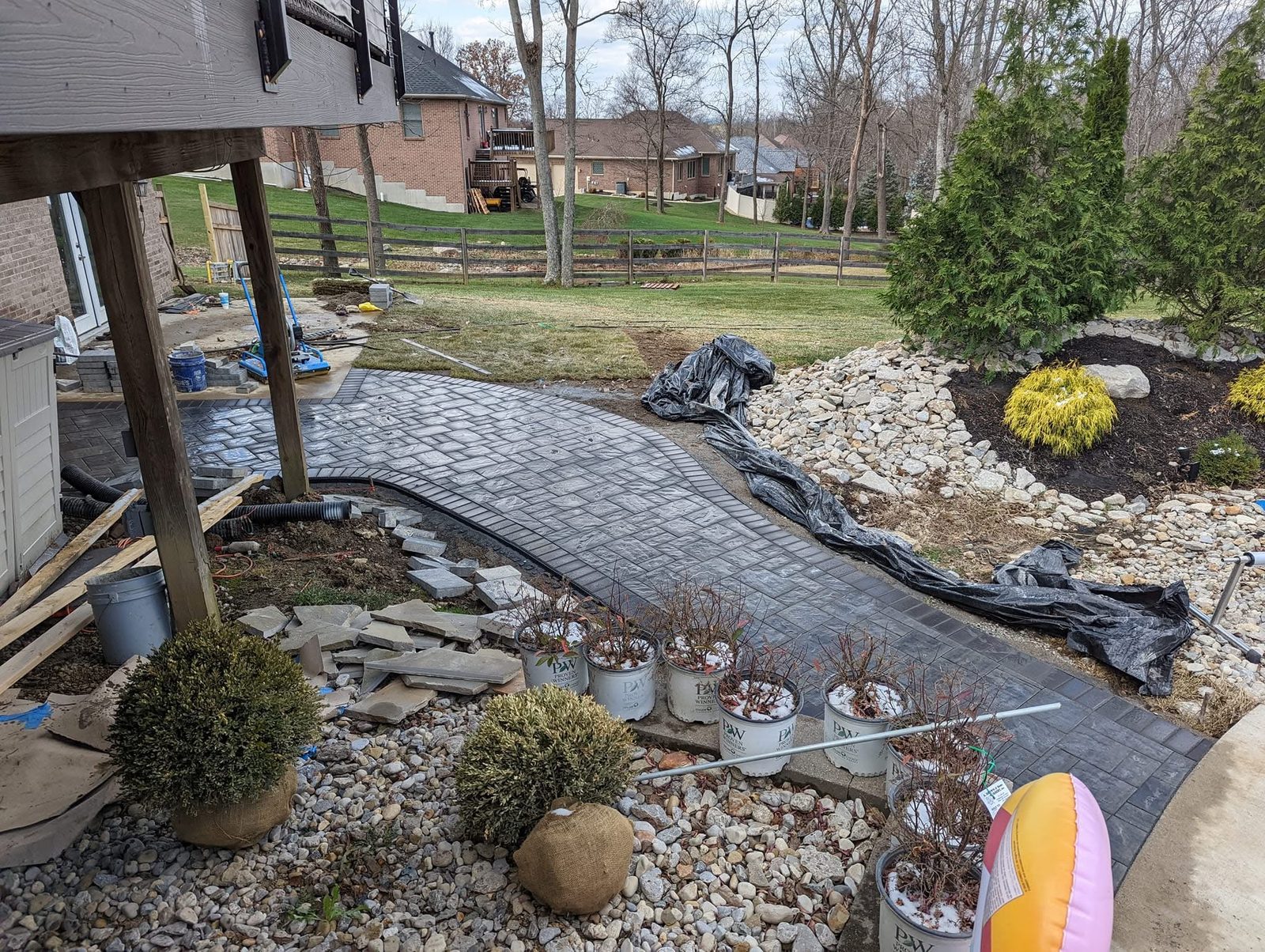 Sweeping gray paver walkway with charcoal border beside a deck