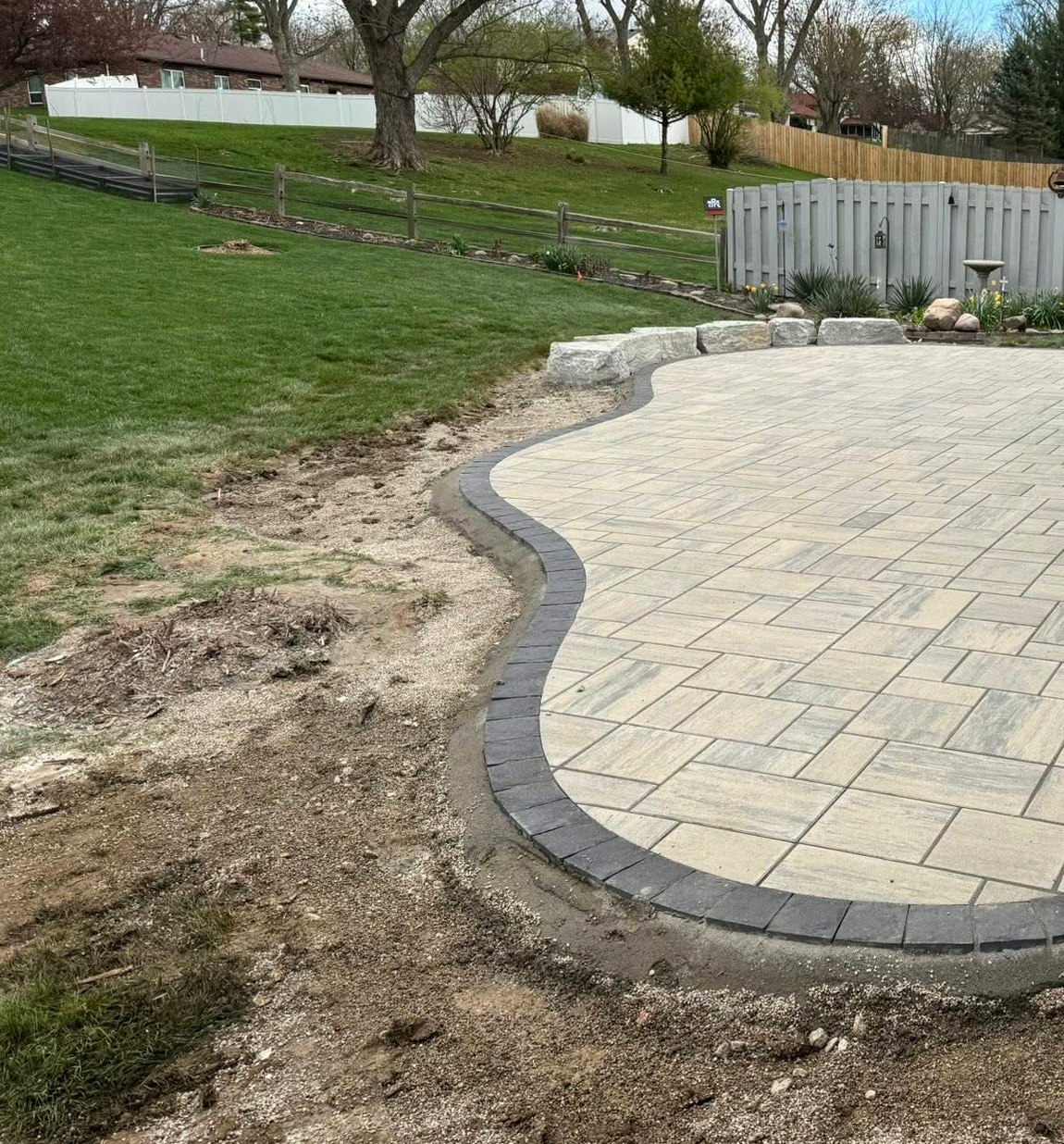 Curved freeform paver patio with stone border