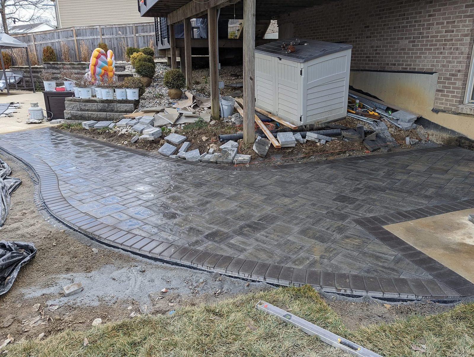 Charcoal herringbone paver patio with soldier-course border