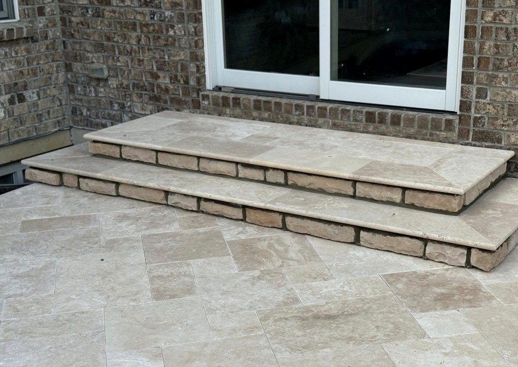 Travertine steps with stone risers against brick